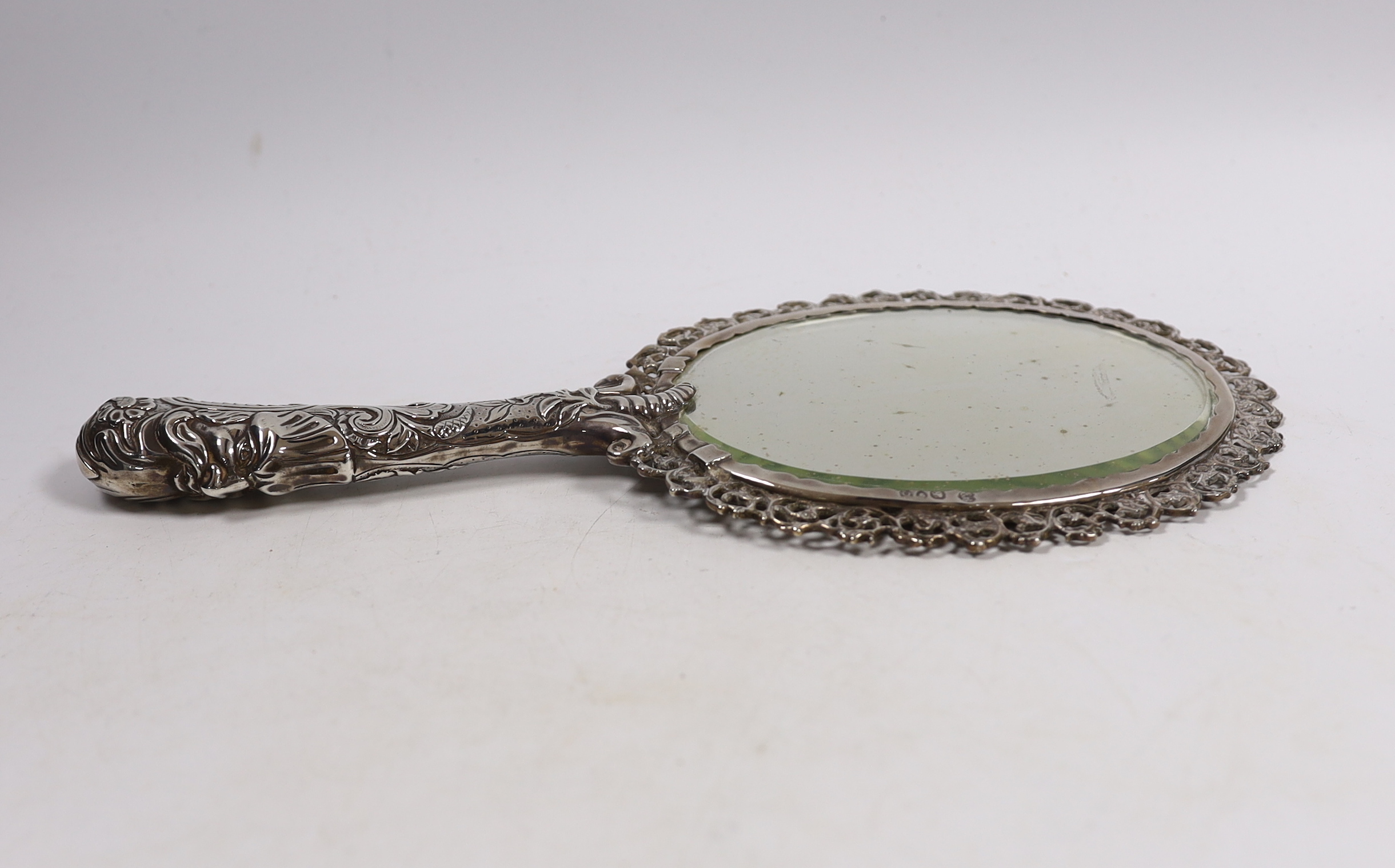 An ornate late Victorian silver mounted hand mirror, Edward Brown, London, 1891, 30.1cm.